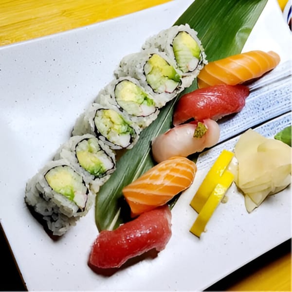 Sushi platter with California rolls, salmon, tuna, and white fish nigiri, ginger, and lemon.